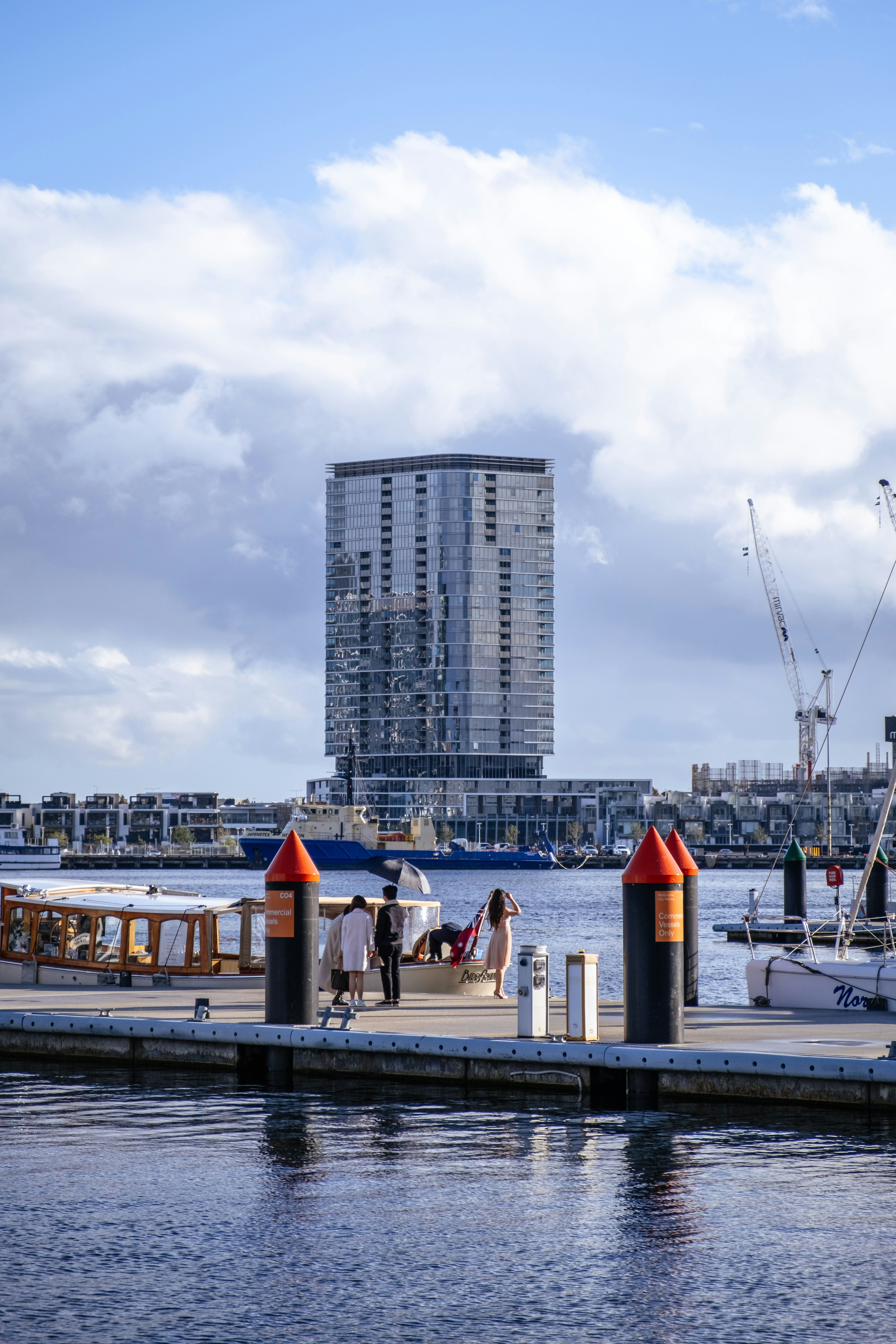 people on boat on dock near high rise buildings during daytime